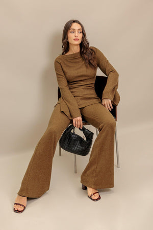 A solid knit pant featuring elasticized waist, flare leg and tassel tie. Matching top IT13842