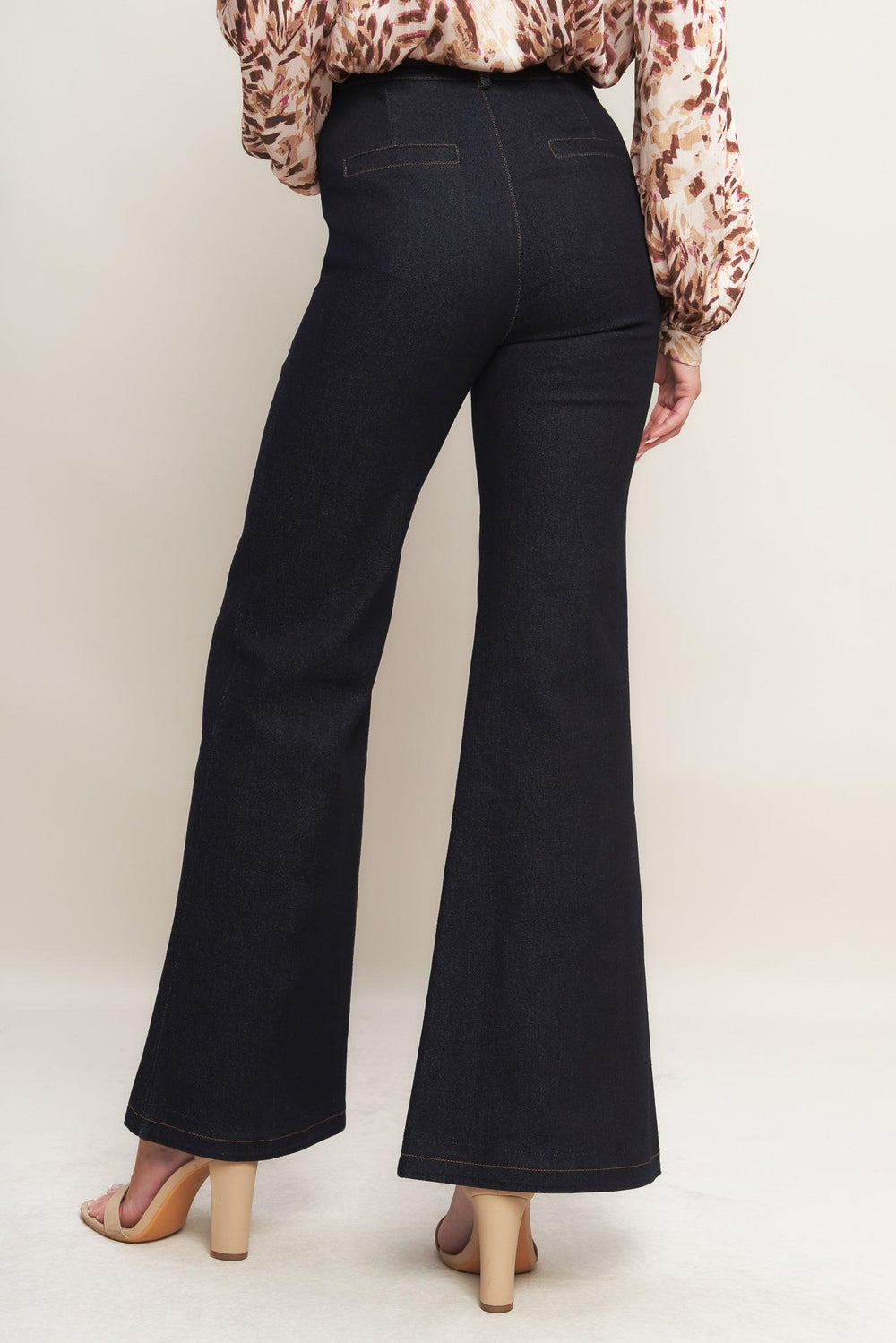 A denim pant featuring front closure, side pockets, self belt and flare leg