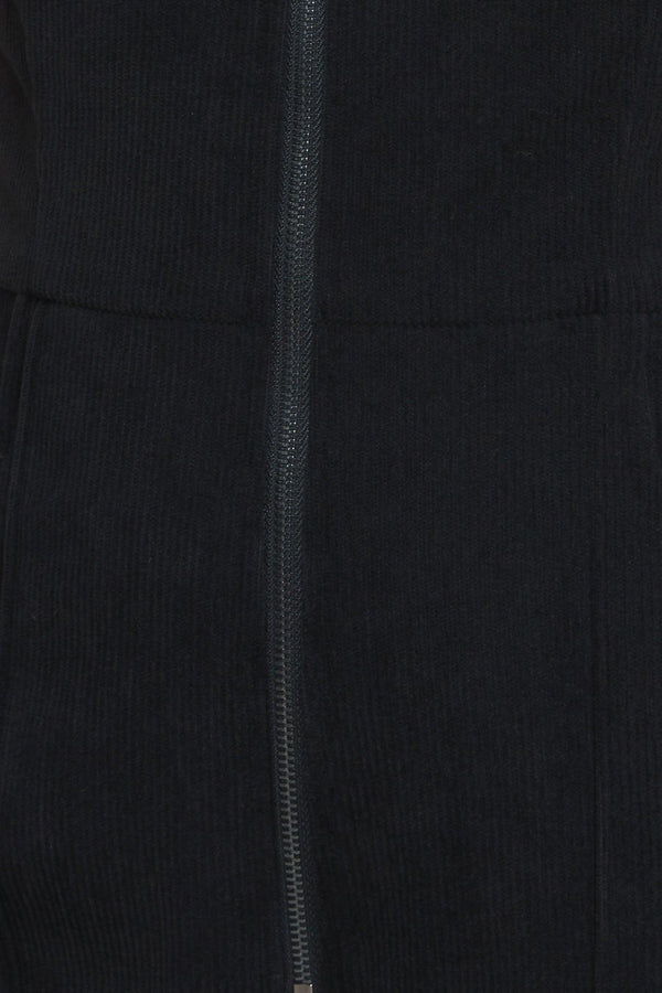 A solid corduroy jumpsuit featuring collar, V neckline, sleeveless, front zipper, waist yoke, side pocket and flare leg