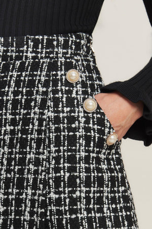 A tweed skort featuring button detail and side zipper closure