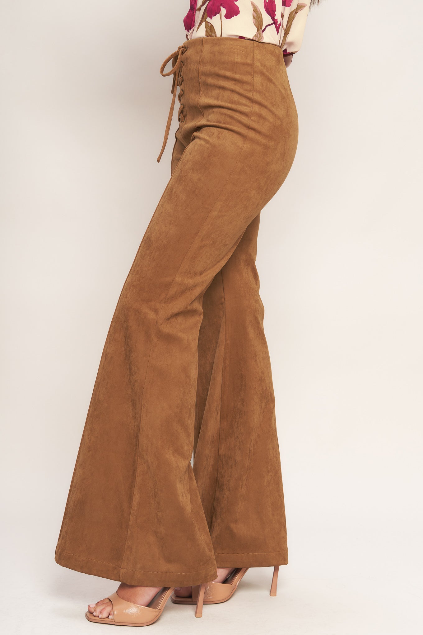 A faux suede pant featuring front lace up detail, flare leg and back zipper closure