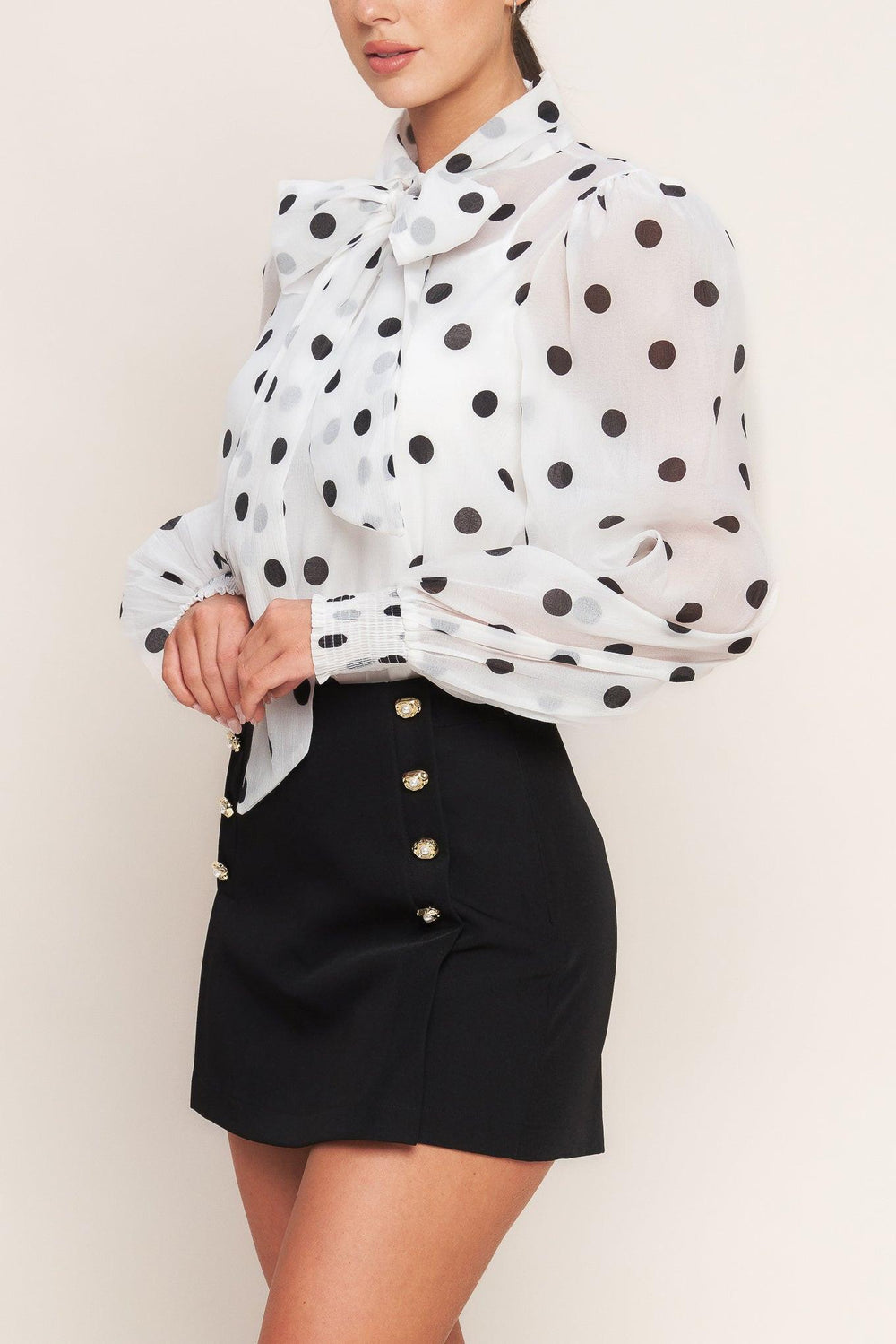 A solid woven skort featuring double button down detail and side zipper closure