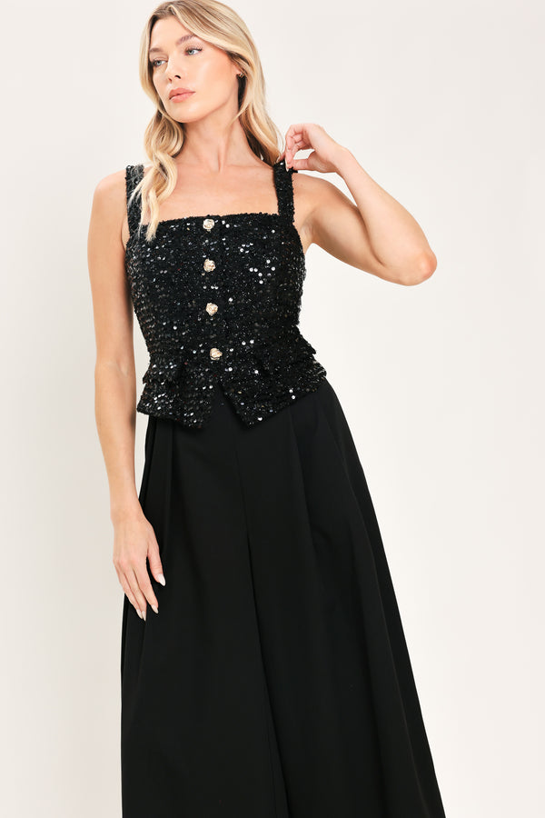 Woman wearing a sleeveless, square-neckline black jumpsuit with sparkly top and solid bottoms | Flying Tomato