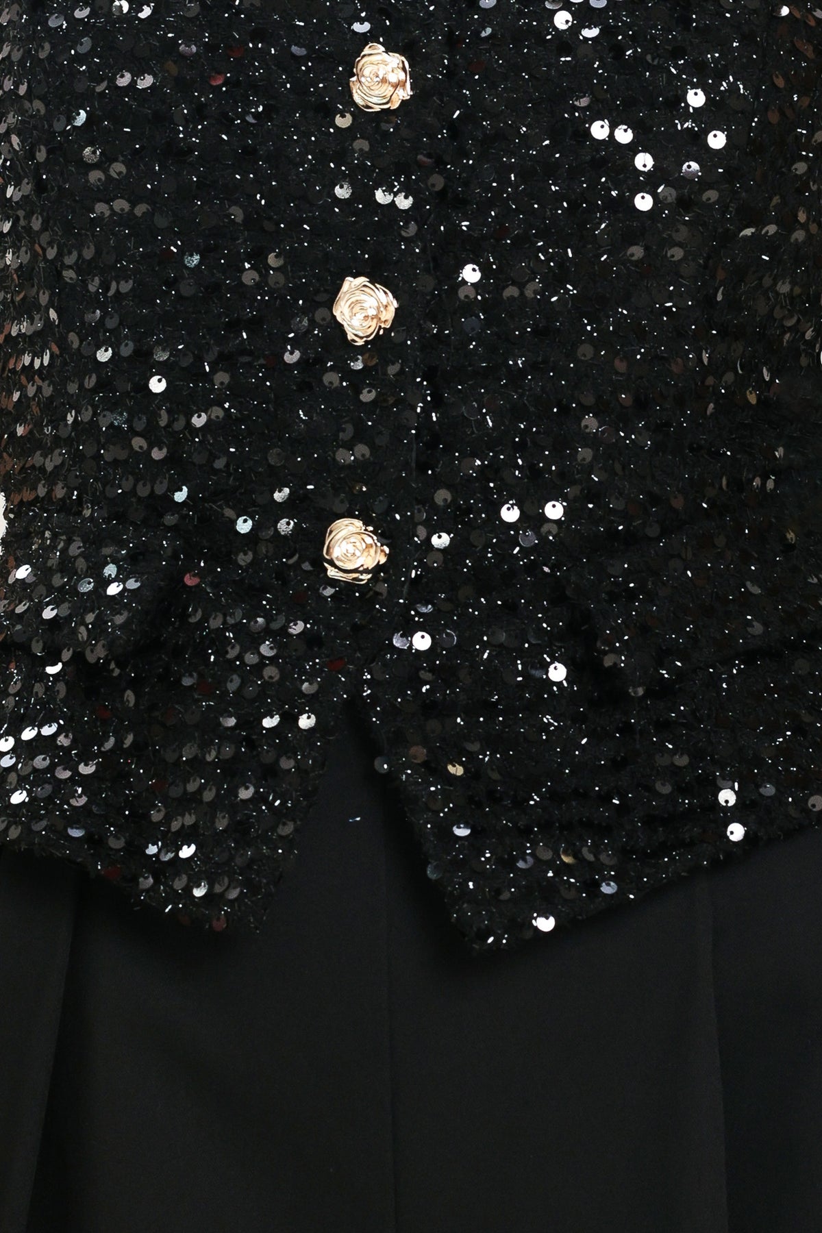 Woman wearing a sleeveless, square-neckline black jumpsuit with sparkly top and solid bottoms | Flying Tomato