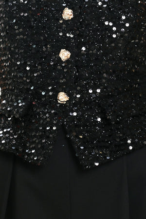 Woman wearing a sleeveless, square-neckline black jumpsuit with sparkly top and solid bottoms | Flying Tomato