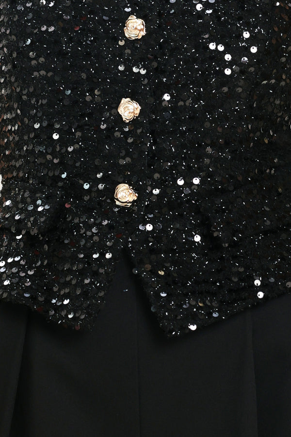 Woman wearing a sleeveless, square-neckline black jumpsuit with sparkly top and solid bottoms | Flying Tomato