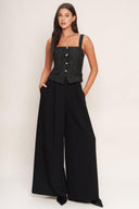 A woven jumpsuit featuring tweed bodice with straight neckline and strap, button down detail, solid woven wide leg pant and back zipper closure