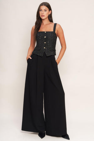 A woven jumpsuit featuring tweed bodice with straight neckline and strap, button down detail, solid woven wide leg pant and back zipper closure