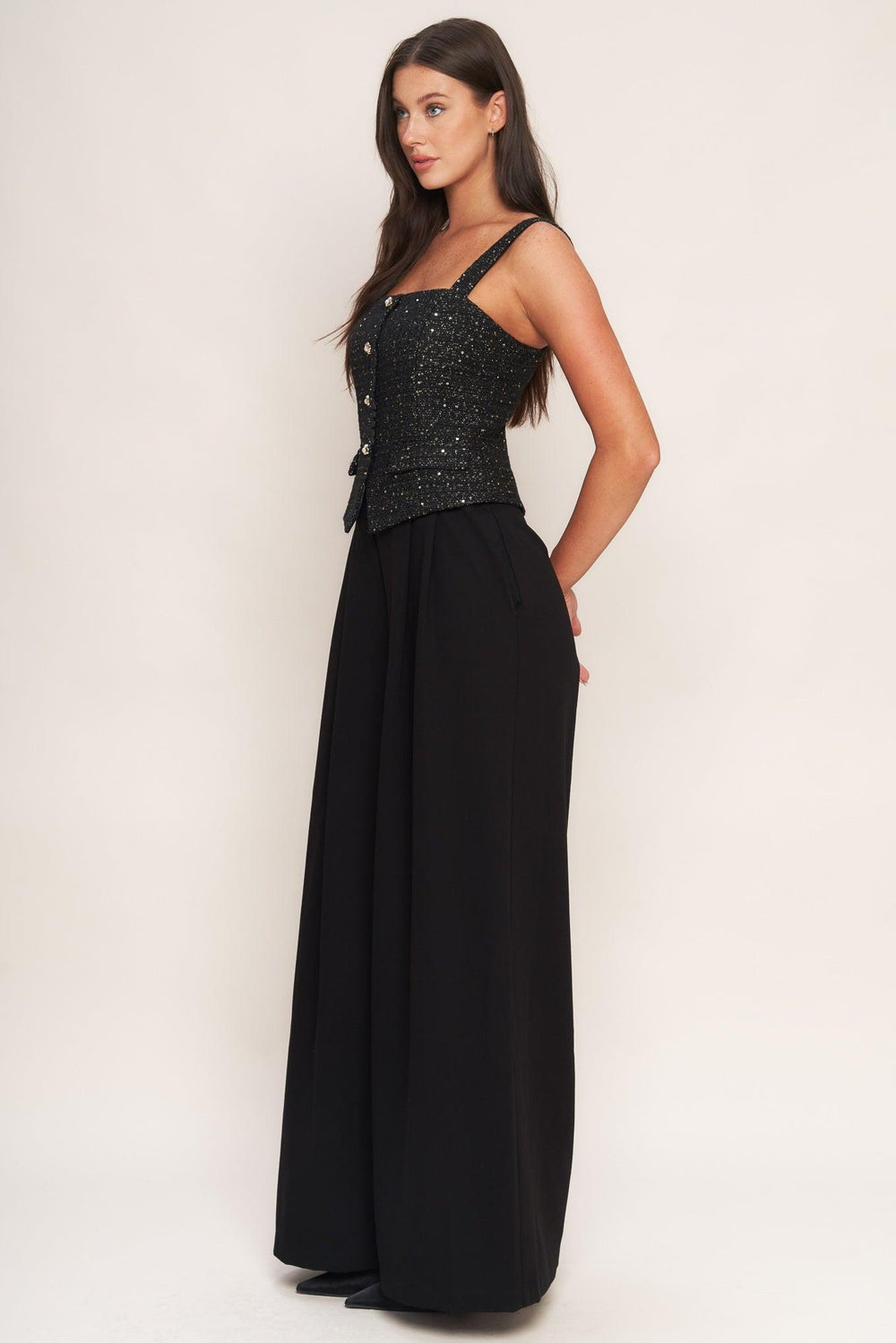 A woven jumpsuit featuring tweed bodice with straight neckline and strap, button down detail, solid woven wide leg pant and back zipper closure