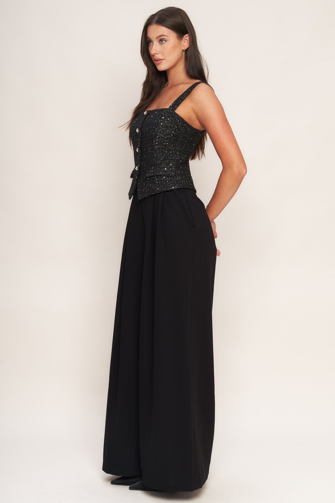 A woven jumpsuit featuring tweed bodice with straight neckline and strap, button down detail, solid woven wide leg pant and back zipper closure