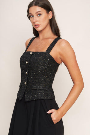 A woven jumpsuit featuring tweed bodice with straight neckline and strap, button down detail, solid woven wide leg pant and back zipper closure