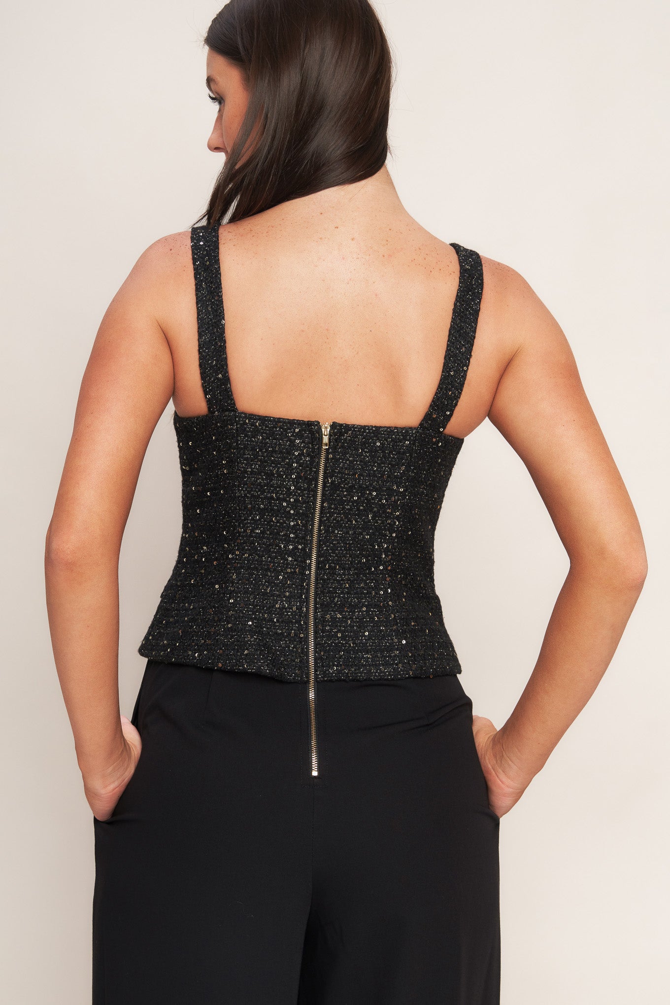 A woven jumpsuit featuring tweed bodice with straight neckline and strap, button down detail, solid woven wide leg pant and back zipper closure