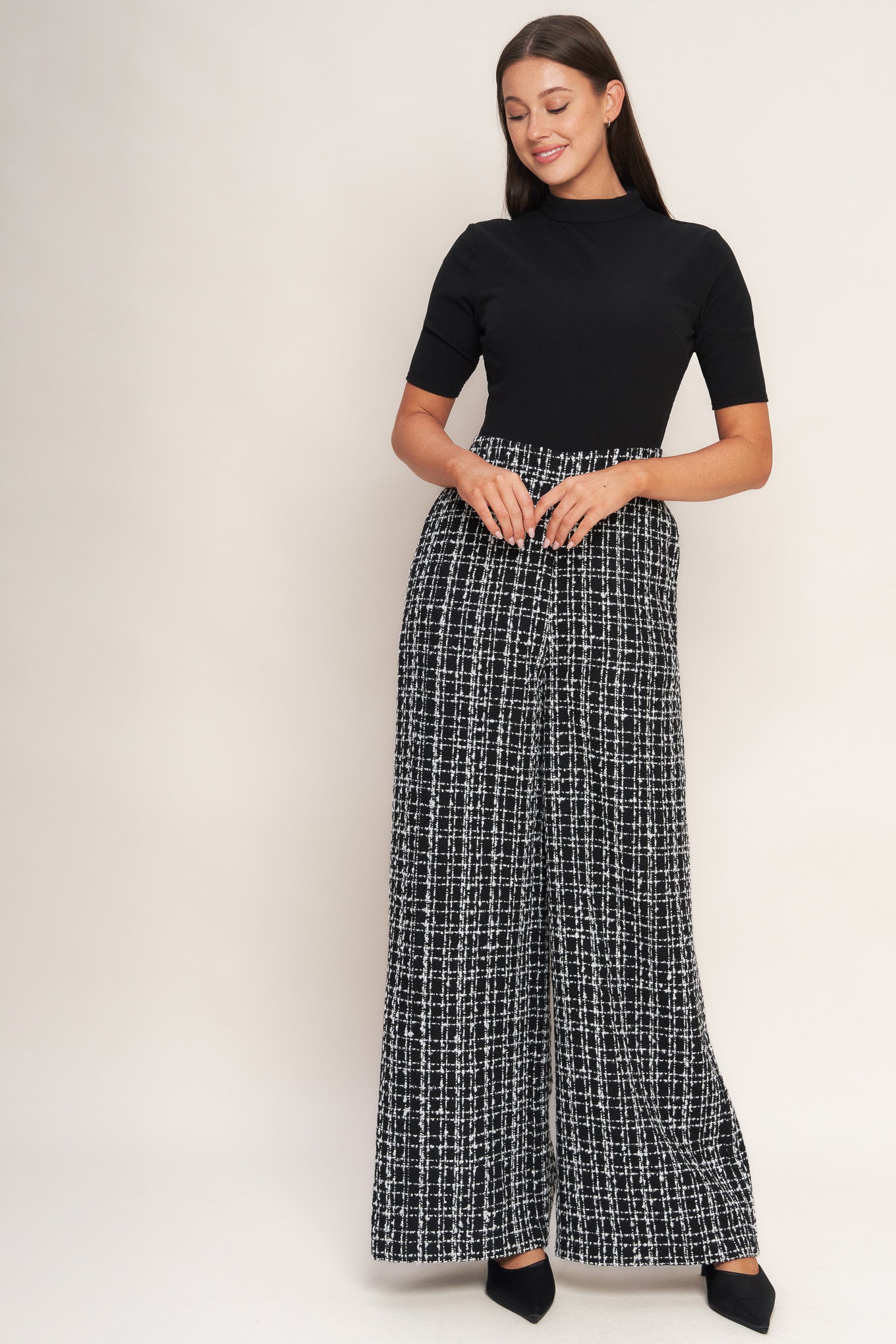 A ribbed knit top and tweed pant jumpsuit featuring mock neckline, short sleeve, side leg and back zipper closure