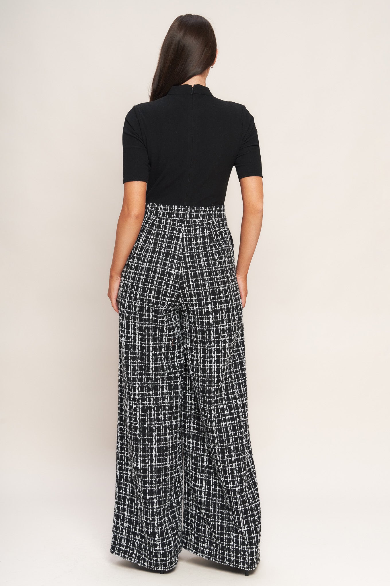 A ribbed knit top and tweed pant jumpsuit featuring mock neckline, short sleeve, side leg and back zipper closure