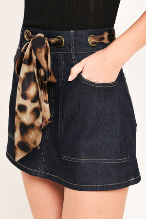 Woman wearing a denim skort with a leopard print ribbon waist tie | Flying Tomato