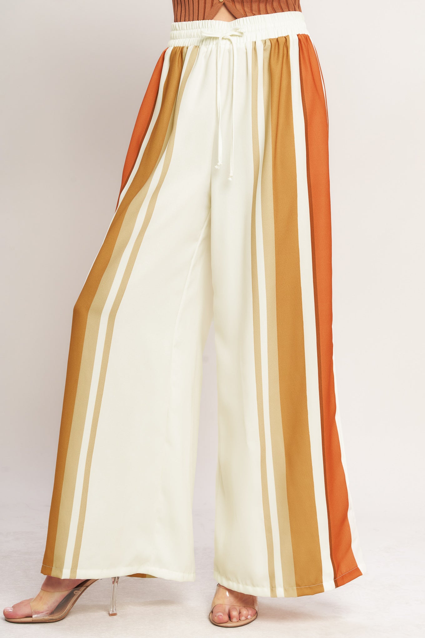 A printed woven pant featuring elastic waist with front tie and wide leg.