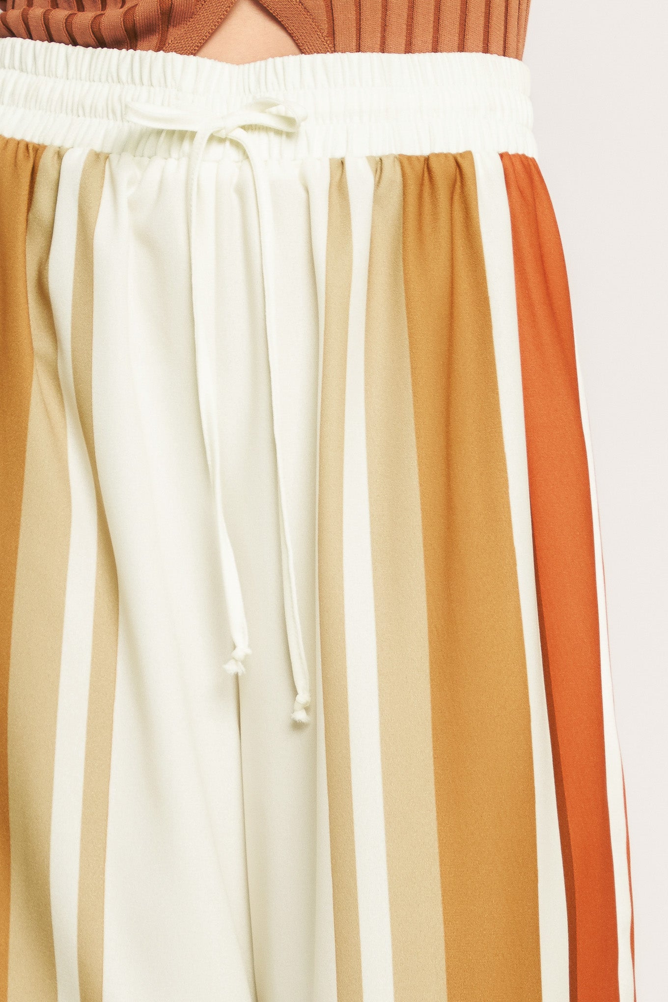 A printed woven pant featuring elastic waist with front tie and wide leg.