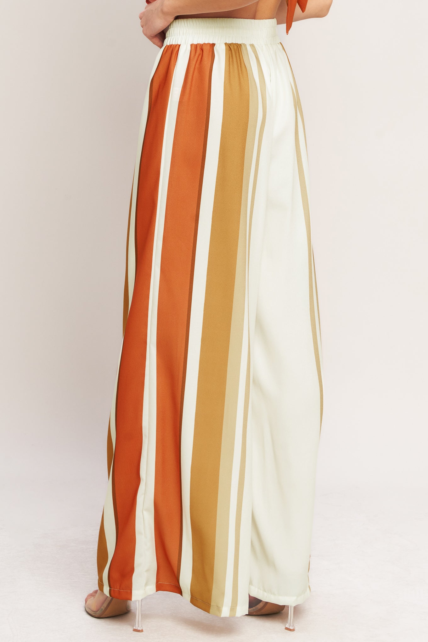 A printed woven pant featuring elastic waist with front tie and wide leg.