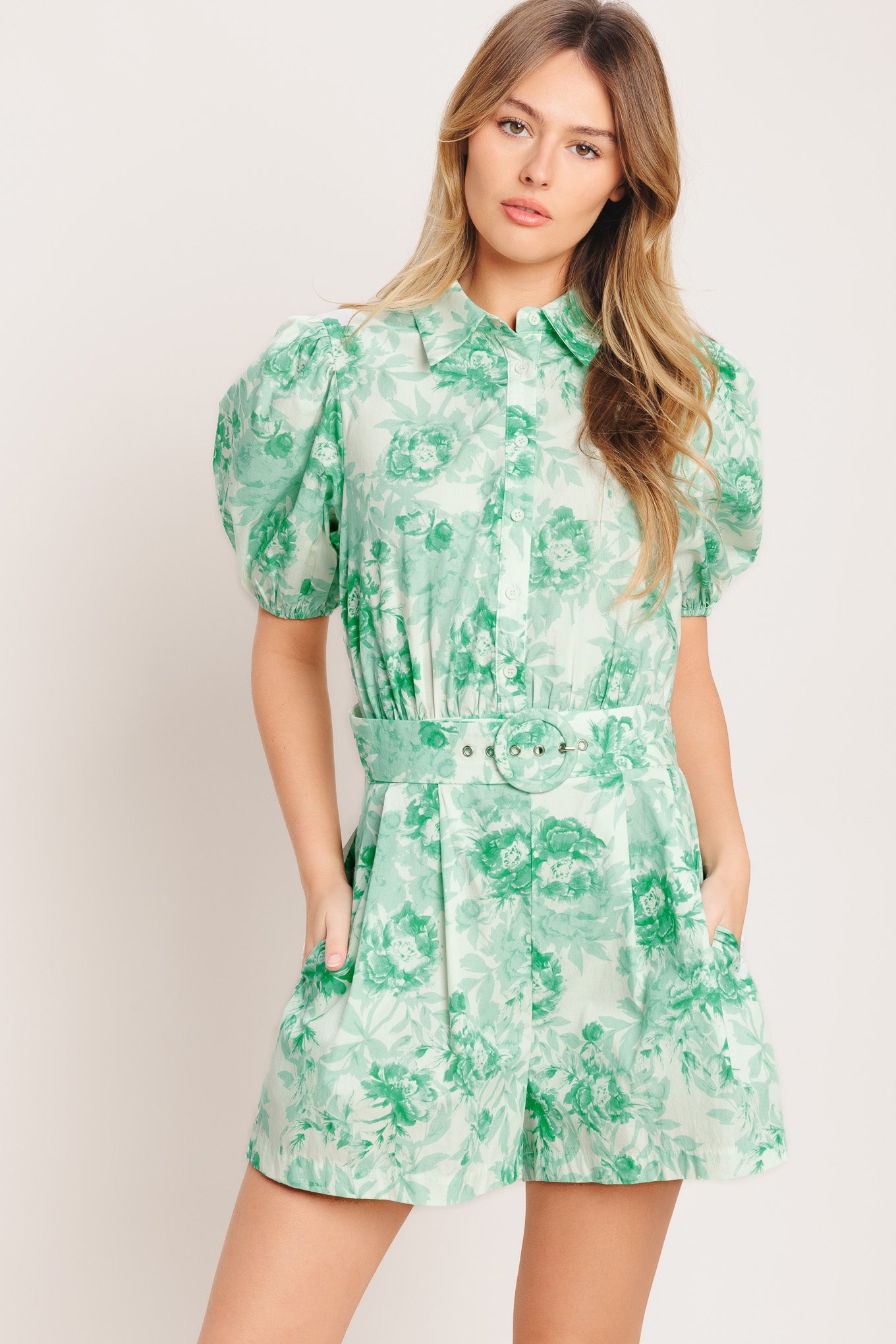 A printed woven romper featuring short puff sleeve, button down detail, front pleats, side pocket and self belt and elasticized back waistband

Details:

Self: 100% Cotton

Size & Fit

-Model is 5`8" And Wearing Size Small
-Measurements Taken From Size Small
-Approx. Length: 33"