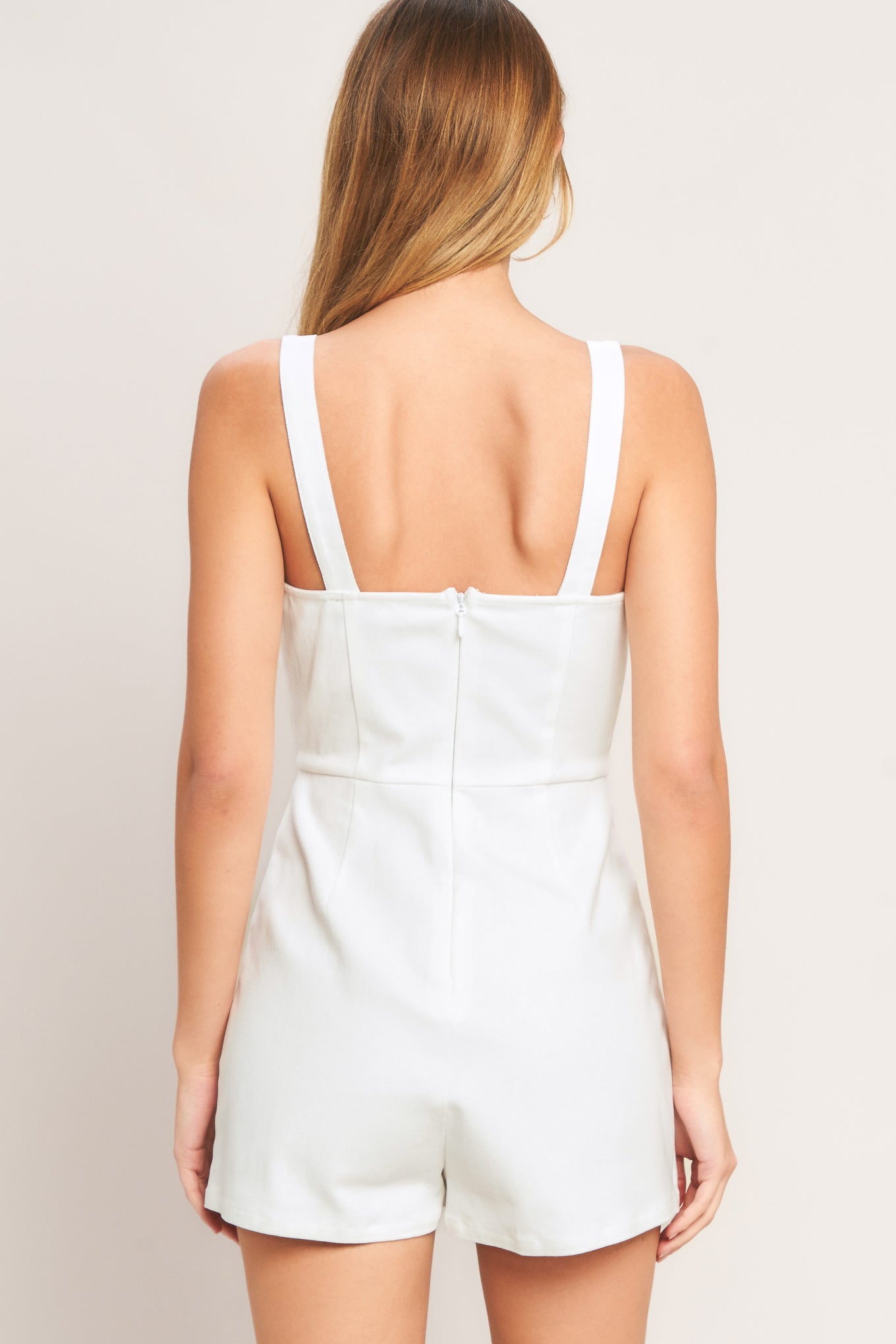 White romper worn by a person on a plain background