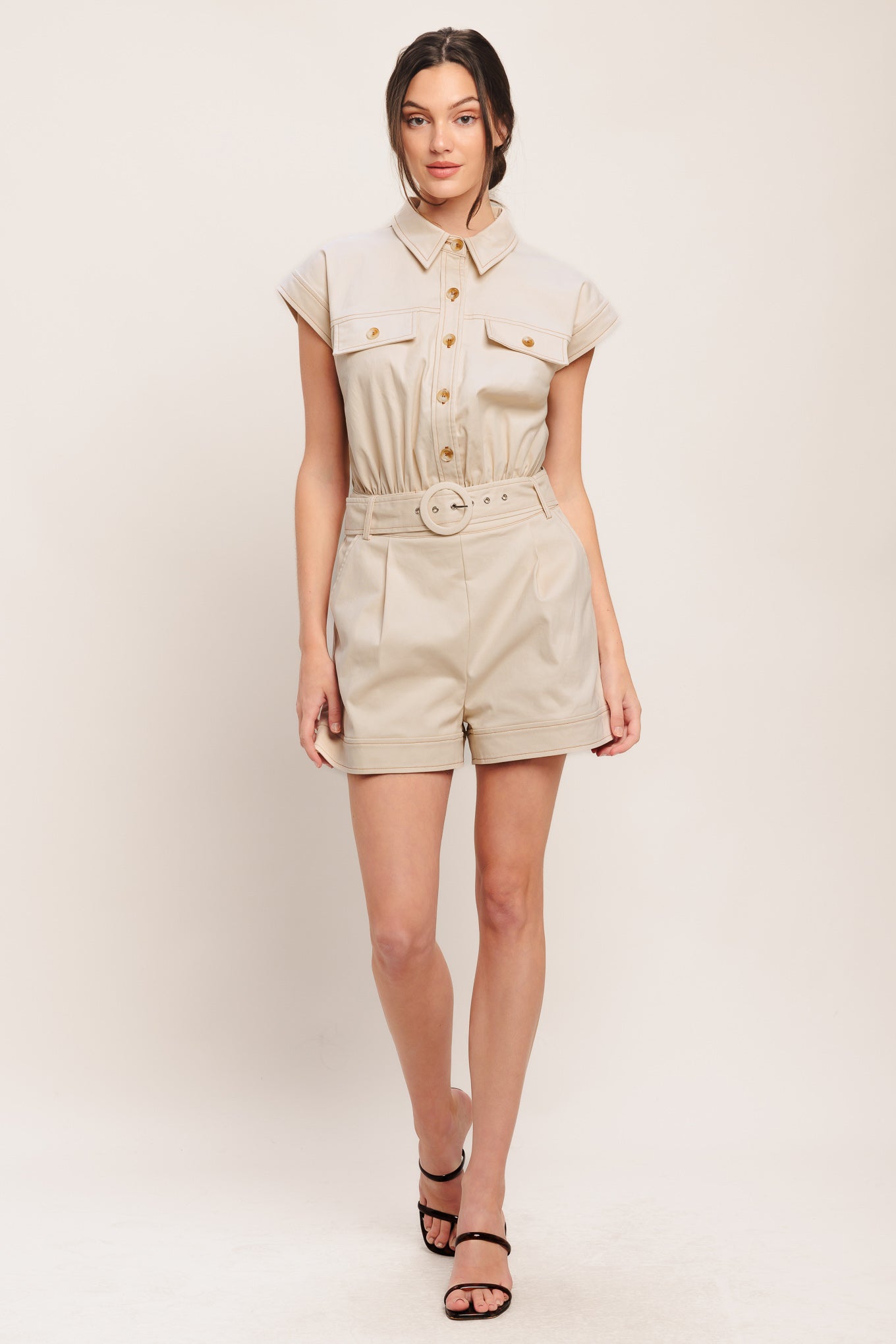 A solid woven romper featuring collar, short sleeve, button down, self belt, side and front pockets, and elastic back

Details:

Self: 97% Cotton 3% Spandex

Size & Fit

-Model is 5`8" And Wearing Size Small
-Measurements Taken From Size Small
-Approx. Length: 34"