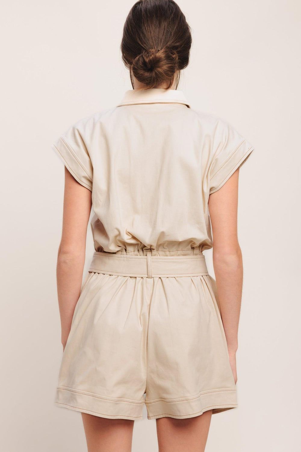 A solid woven romper featuring collar, short sleeve, button down, self belt, side and front pockets, and elastic back

Details:

Self: 97% Cotton 3% Spandex

Size & Fit

-Model is 5`8" And Wearing Size Small
-Measurements Taken From Size Small
-Approx. Length: 34"