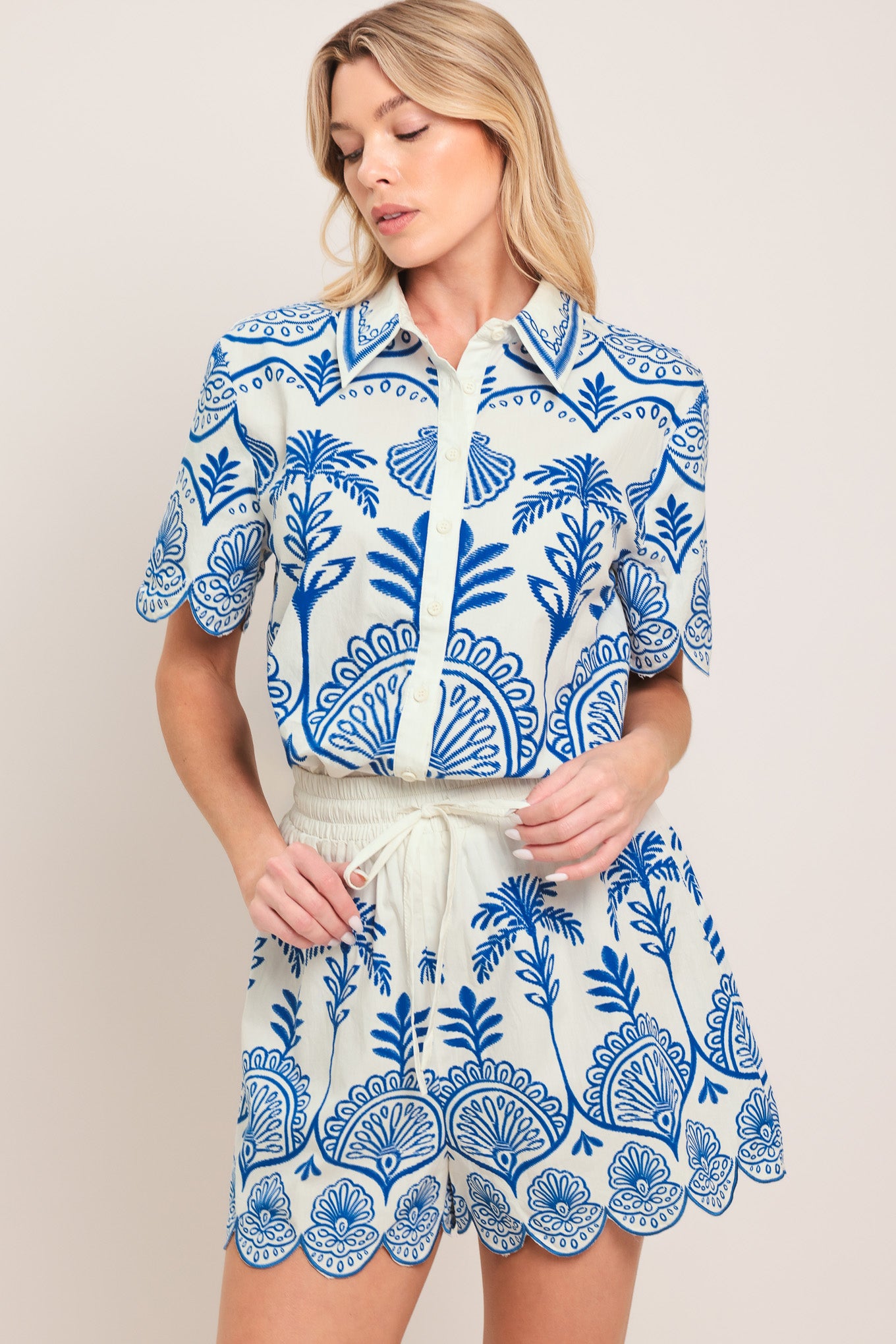 Woman wearing whit and blue shorts with elastic waist with tie and scallop edge | Flying Tomato