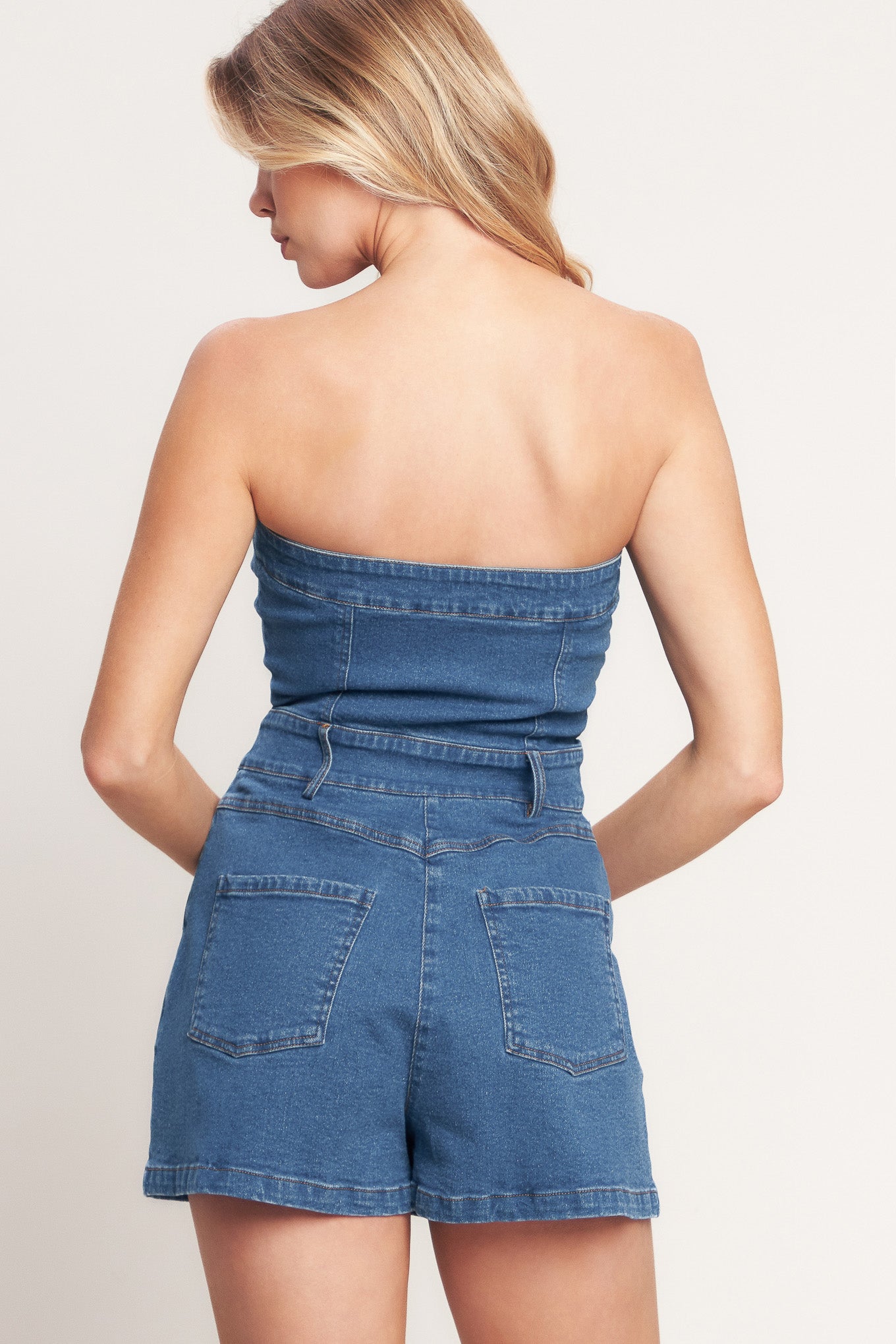 A washed denim romper featuring strapless, front button/zipper closure and pockets

Details:

Self: 98% Cotton 2% Spandex

Size & Fit

- Model is 5`8" And Wearing Size Small
- Measurements Taken From Size Small
- Approx. Length: 24"