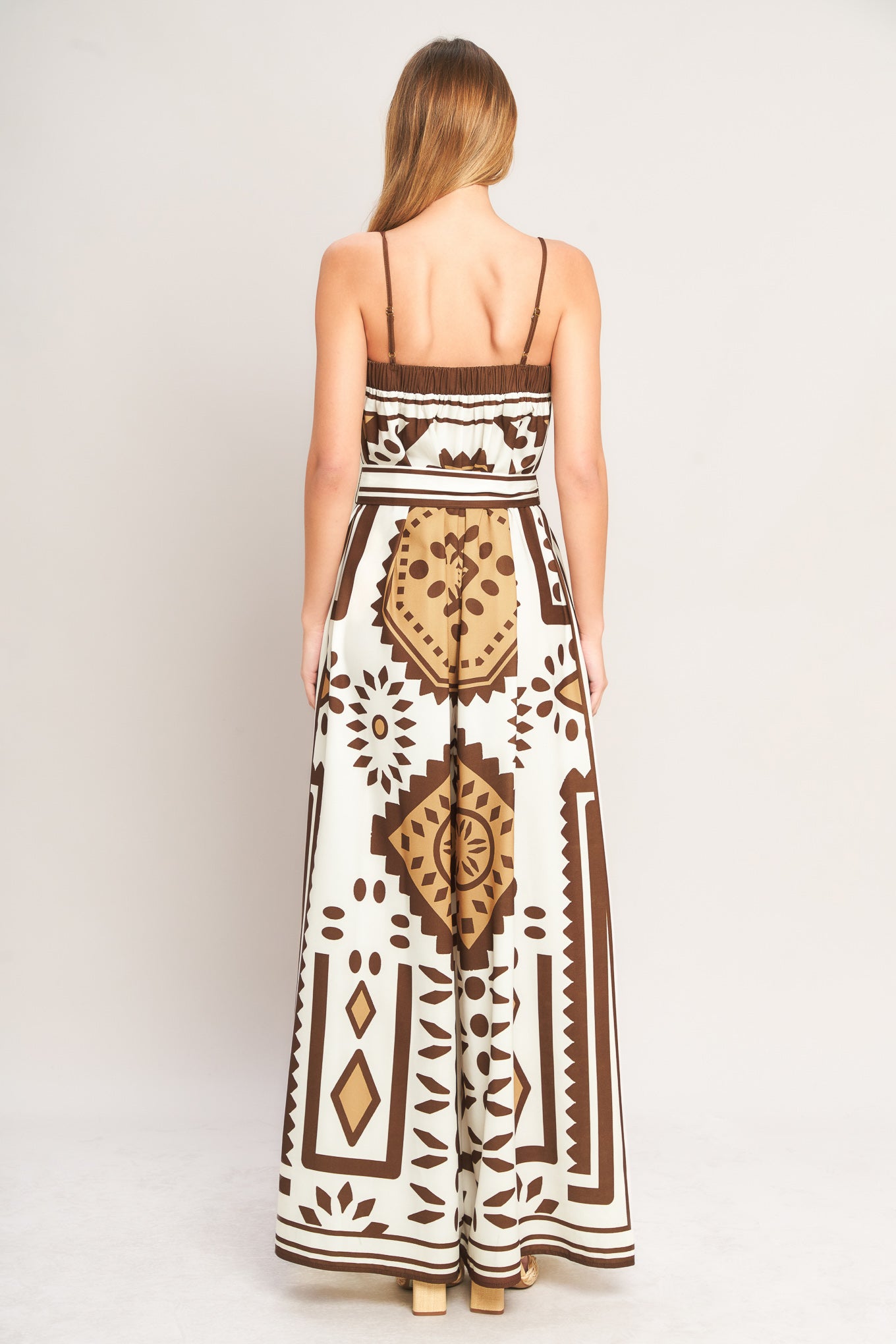 Woman wearing a long dress with a geometric pattern on a white background