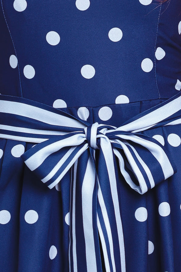 Navy blue jumpsuit with white polka dots and a large white bow at the waist | Flying Tomato