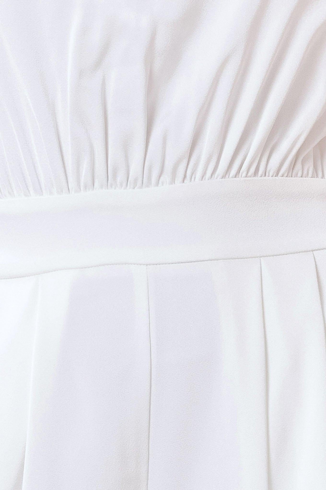 Close-up of a white dress with pleated details