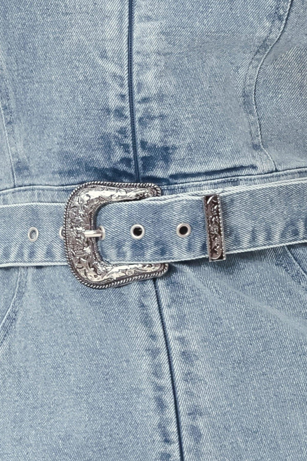 Close-up of a denim jacket with a decorative belt buckle.