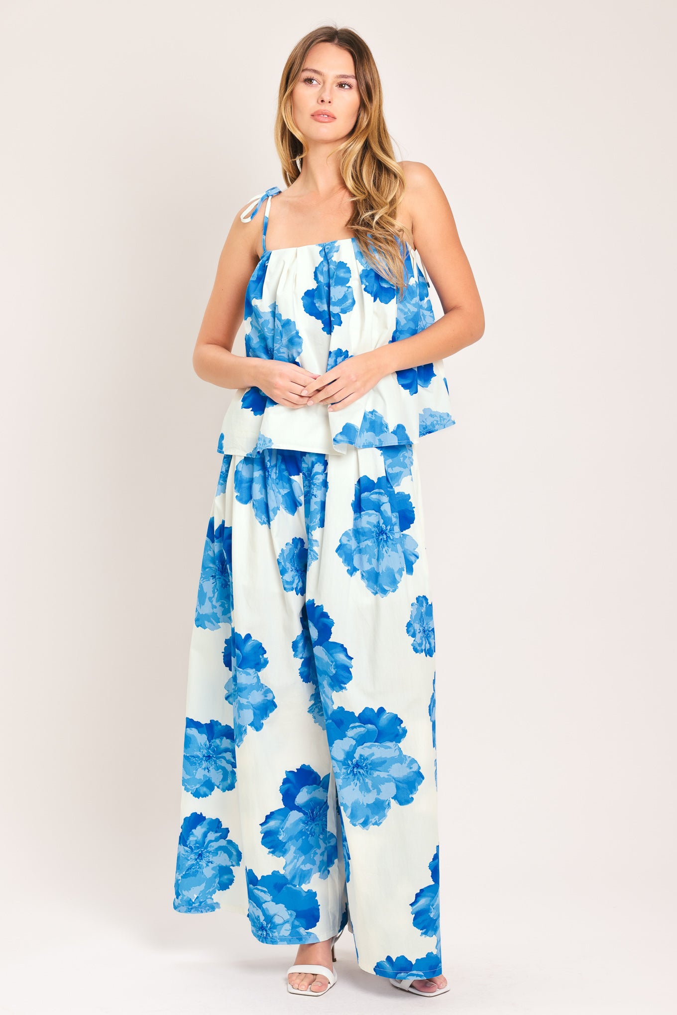 Woman wearing white wide-leg pants with blue floral pattern | Flying Tomato