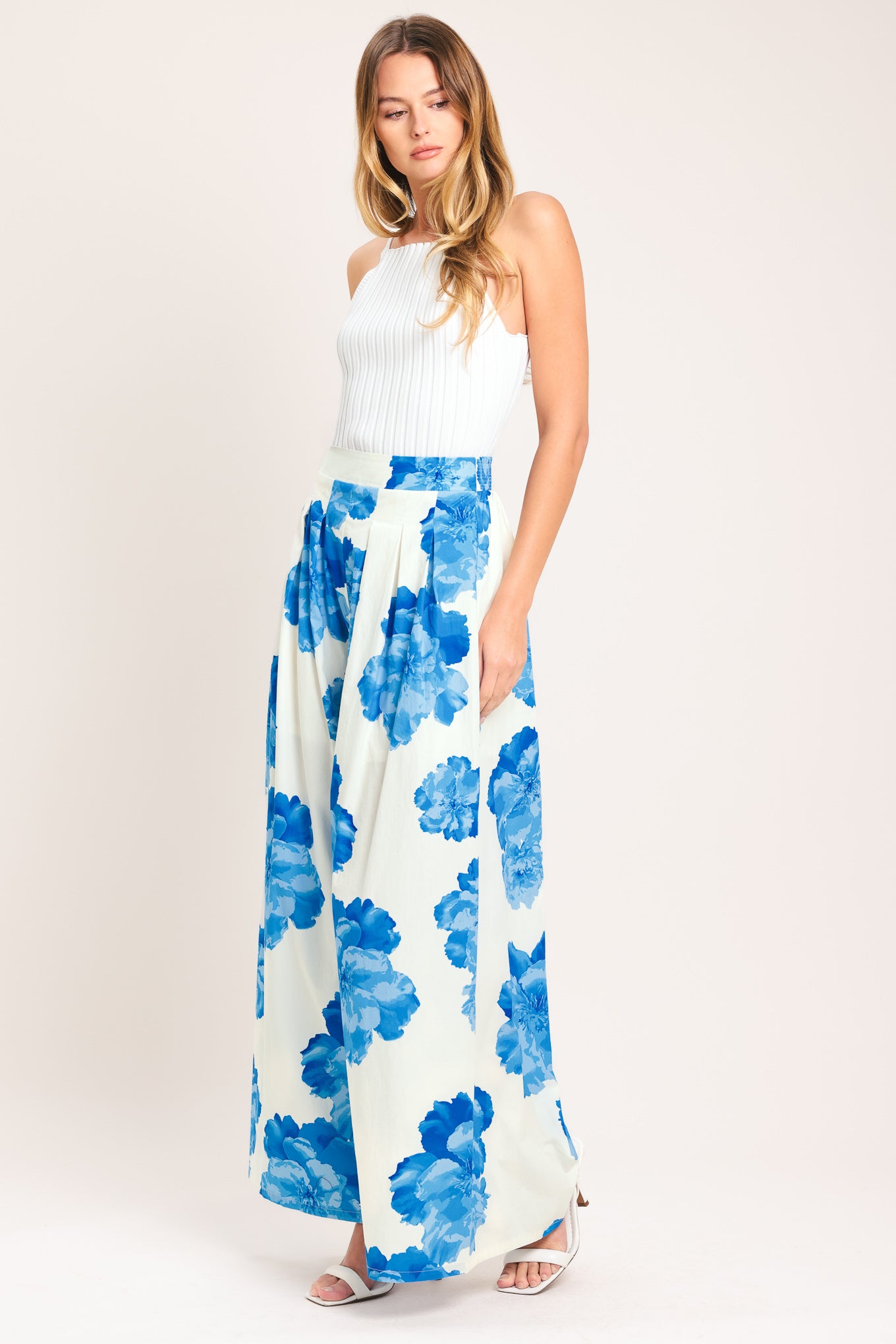 Woman wearing white wide-leg pants with blue floral pattern | Flying Tomato