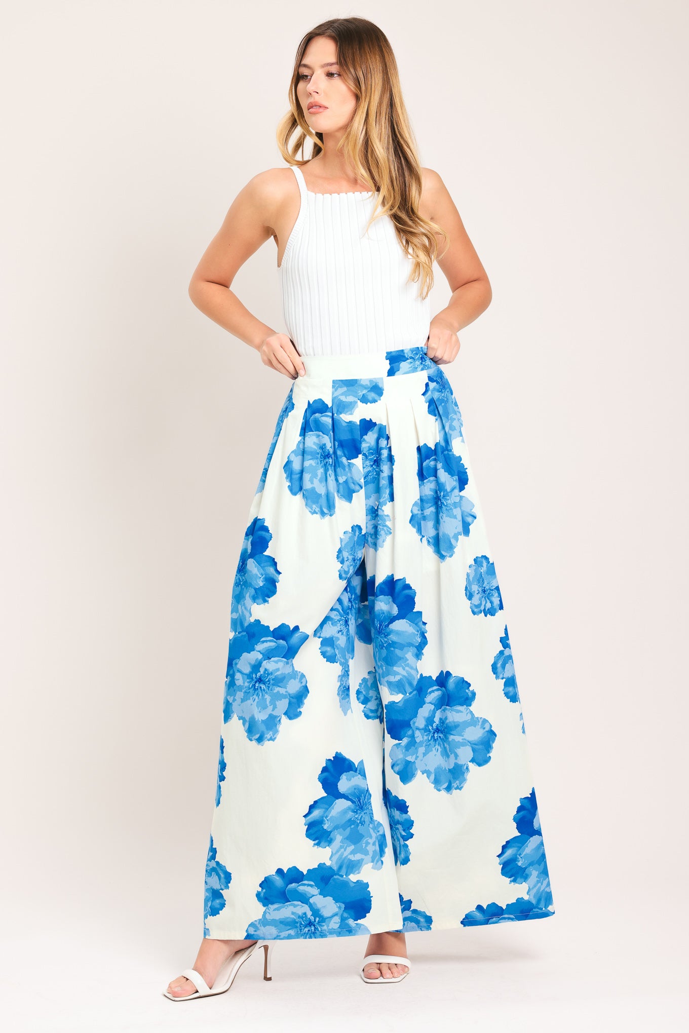 Woman wearing white wide-leg pants with blue floral pattern | Flying Tomato