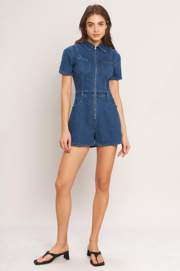 A washed denim romper featuring collar, front zipper closure, short sleeve and pockets