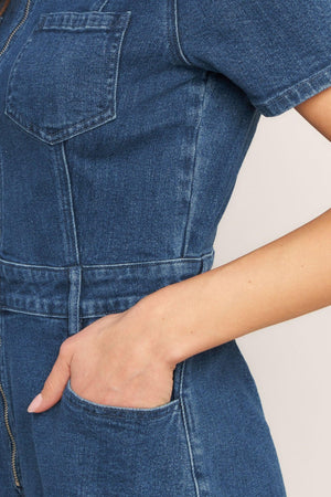 A washed denim romper featuring collar, front zipper closure, short sleeve and pockets
