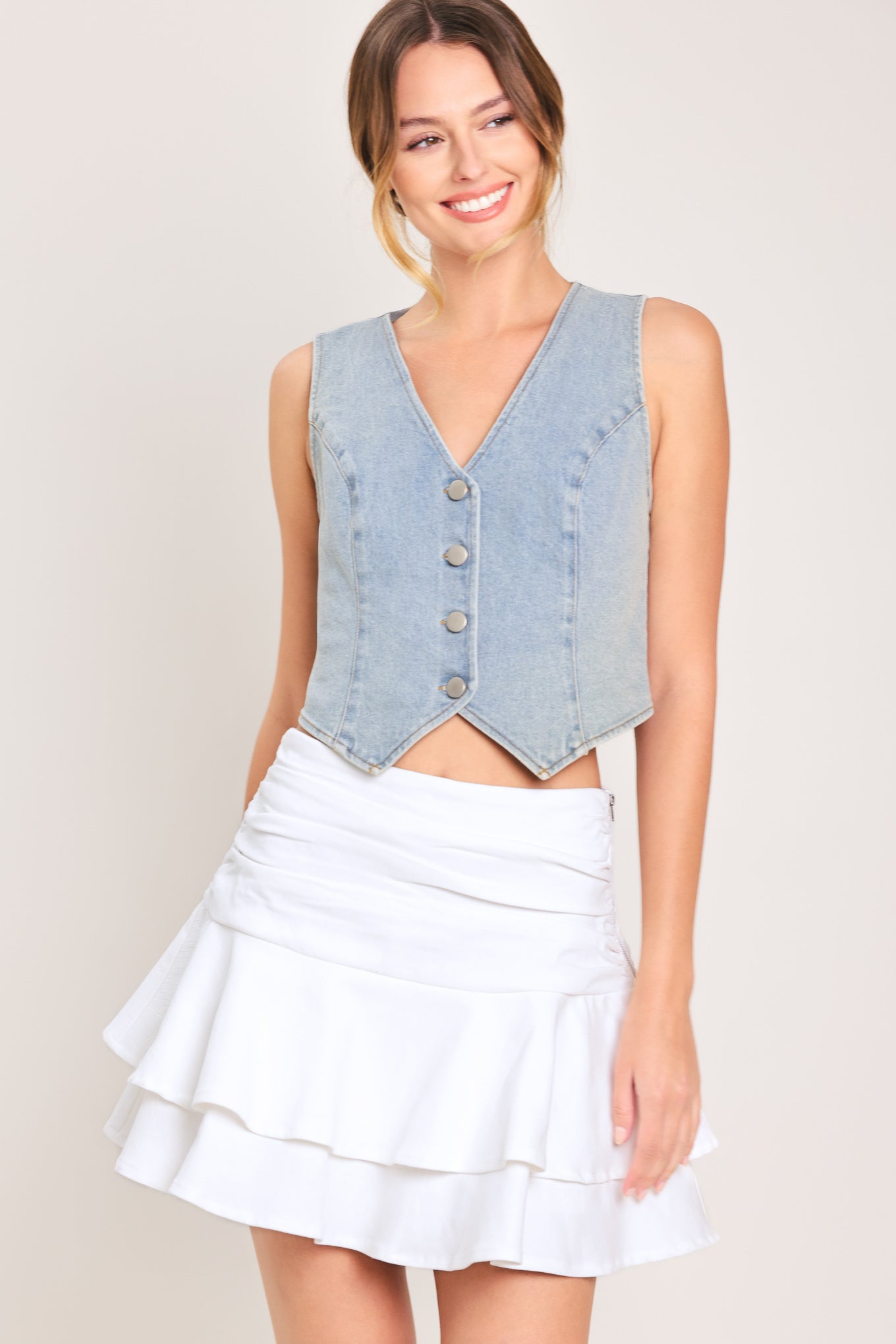 Woman wearing a white ruffled skort featuring side shirring, double ruffle and size zipper closure | Flying Tomato