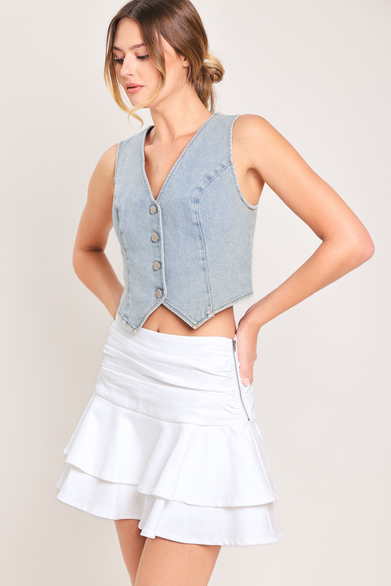 Woman wearing a white ruffled skort featuring side shirring, double ruffle and size zipper closure | Flying Tomato