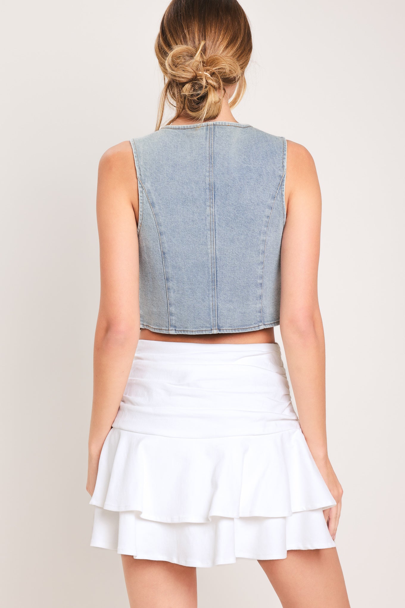 Woman wearing a white ruffled skort featuring side shirring, double ruffle and size zipper closure | Flying Tomato