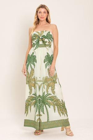 Woman wearing a strapless wide-leg jumpsuit with palm tree pattern featuring front tie and smocked back bodice | Flying Tomato
