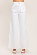 Woman wearing white wide-leg pants with front closure and braided detail waistband | Flying Tomato
