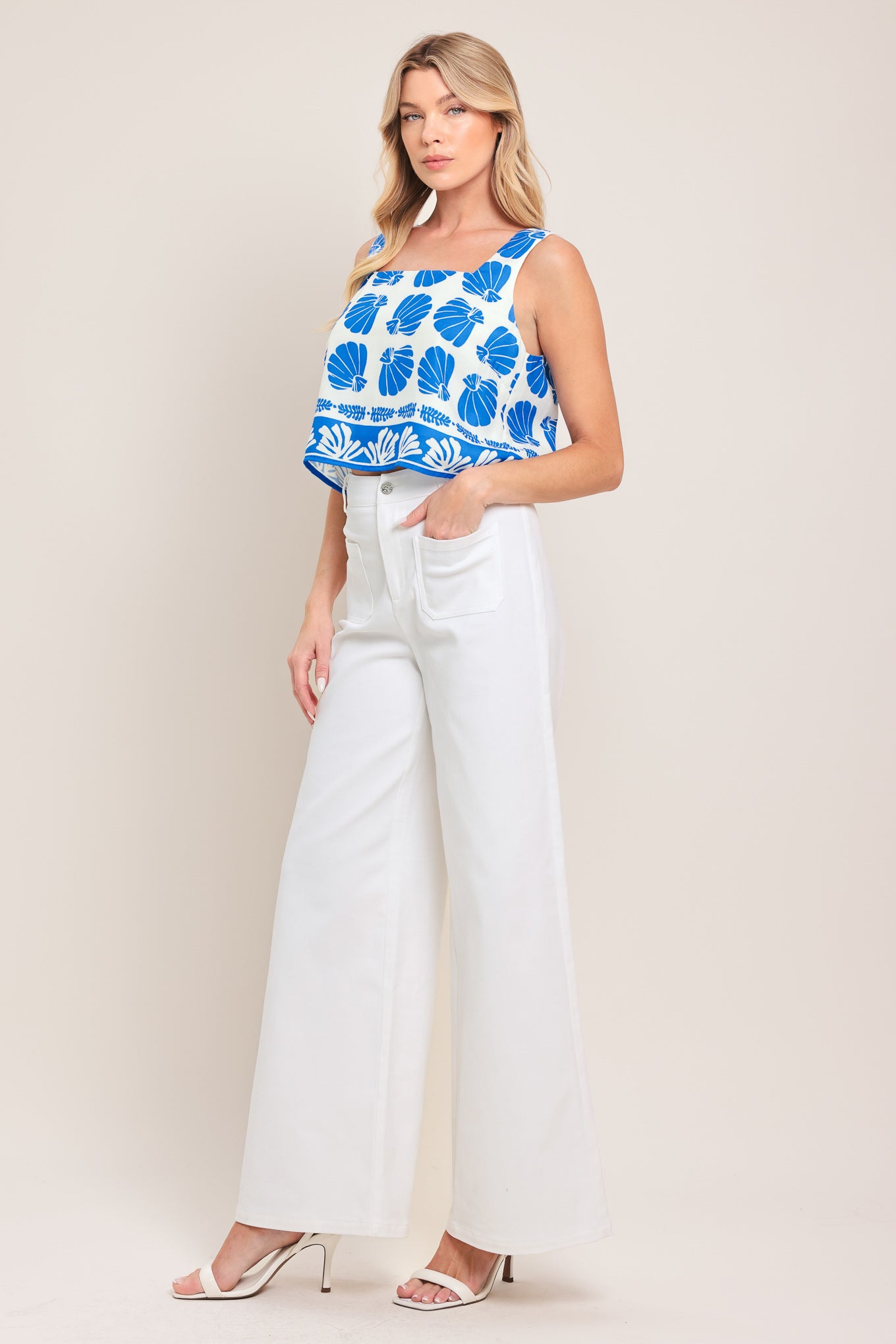 Woman wearing white wide-leg pants with front closure and braided detail waistband | Flying Tomato