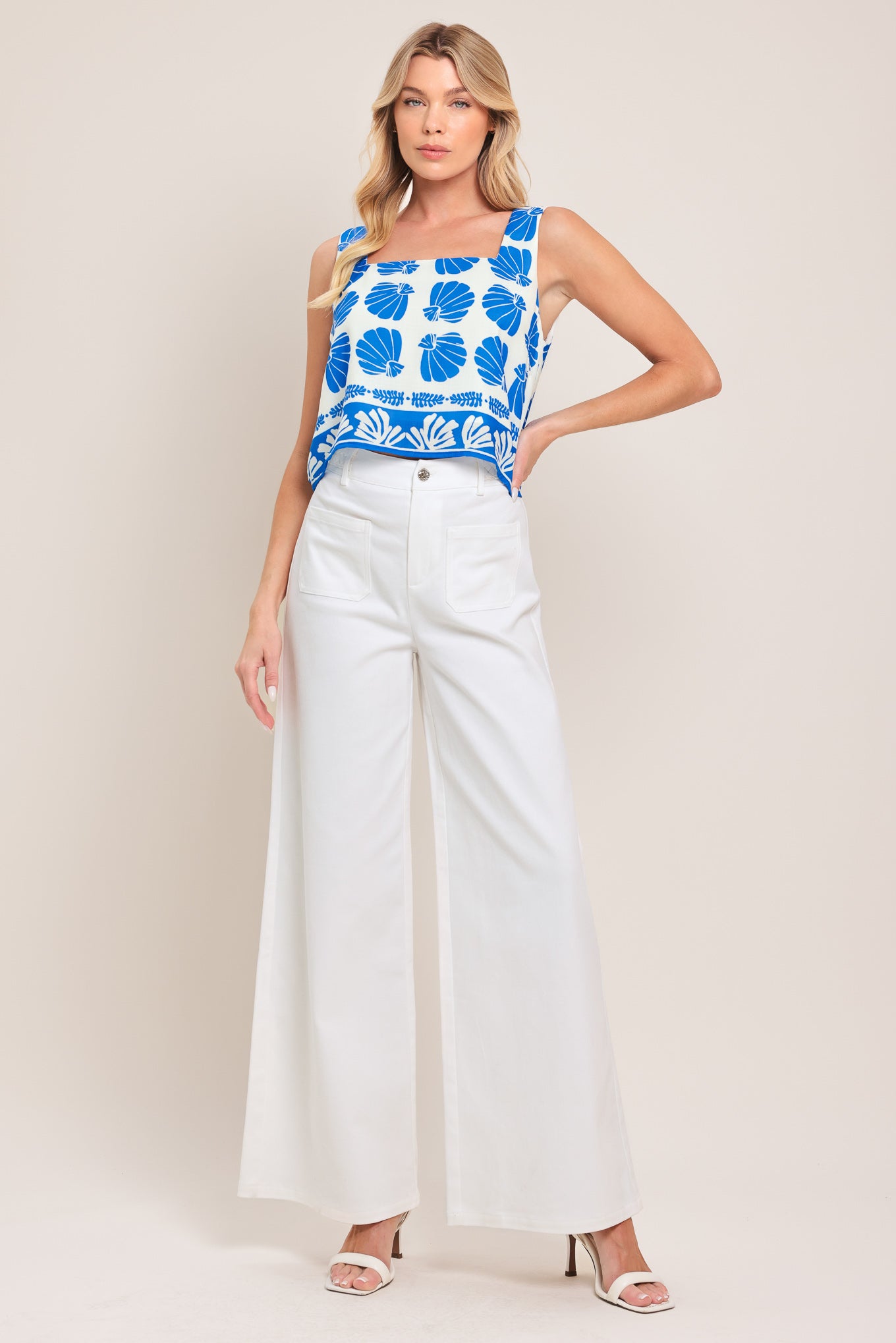 Woman wearing white wide-leg pants with front closure and braided detail waistband | Flying Tomato