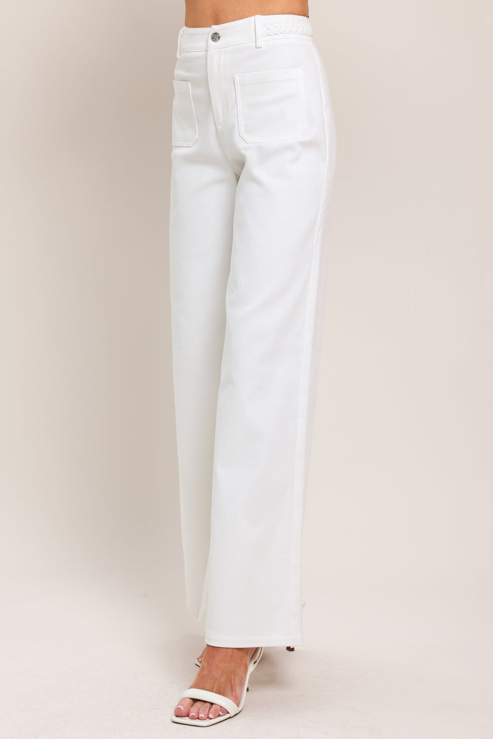 Woman wearing white wide-leg pants with front closure and braided detail waistband | Flying Tomato