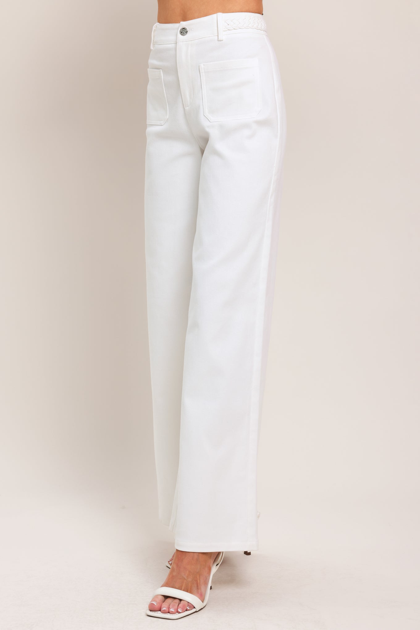 Woman wearing white wide-leg pants with front closure and braided detail waistband | Flying Tomato