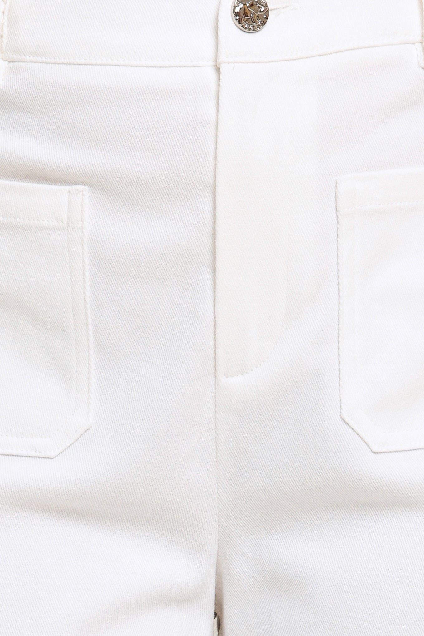 Close-up of white pants with a button and pocket details | Flying Tomato
