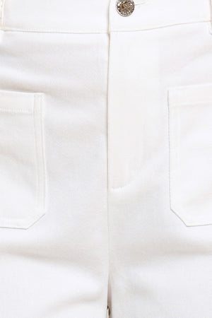 Close-up of white pants with a button and pocket details | Flying Tomato