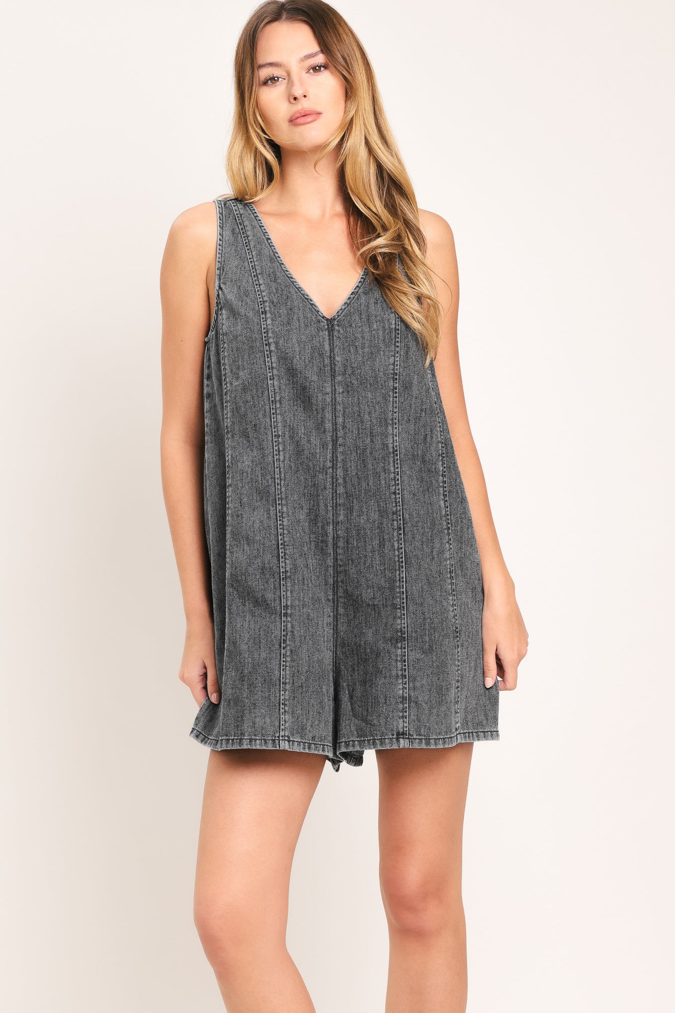 Woman wearing a lightweight denim romper with V neckline and zipper back closure | Flying Tomato