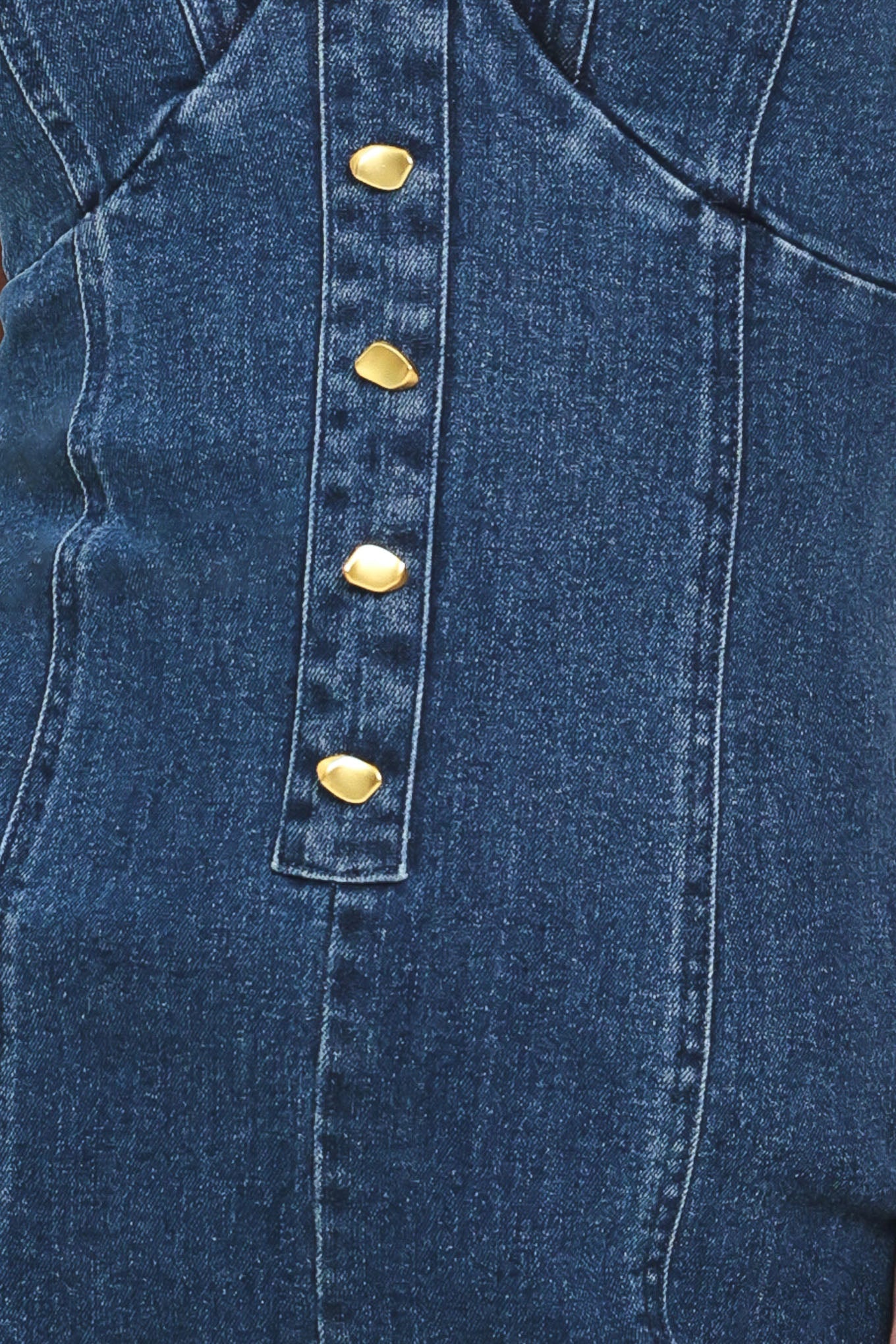 Close-up of a blue denim jumpsuit with gold buttons | Flying Tomato